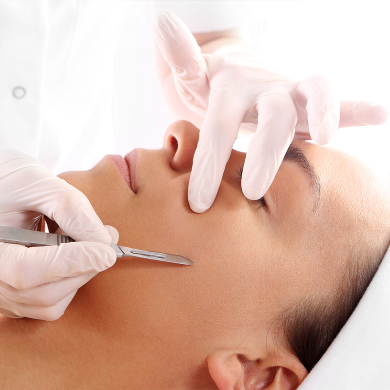 Person receiving a facial treatment from a professional wearing gloves.