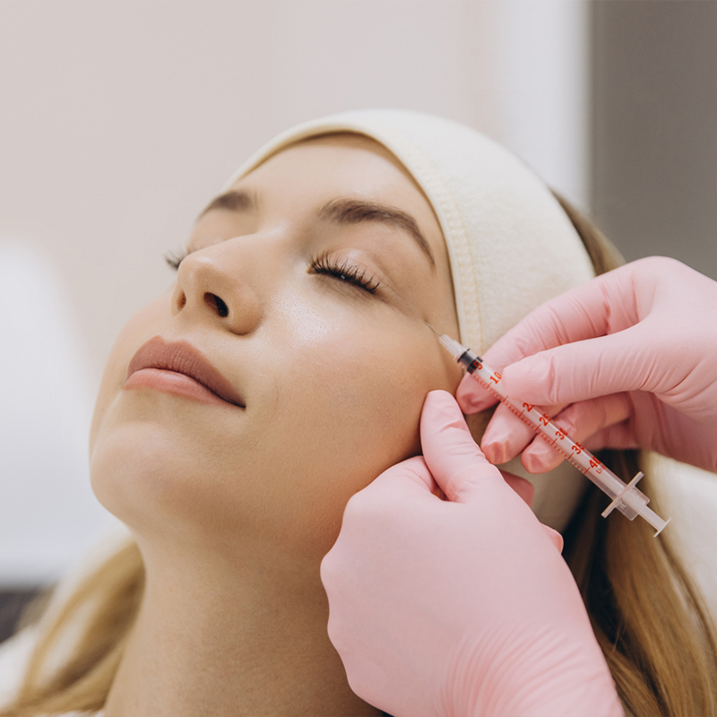 A person receiving a cosmetic injection in a clinic setting.